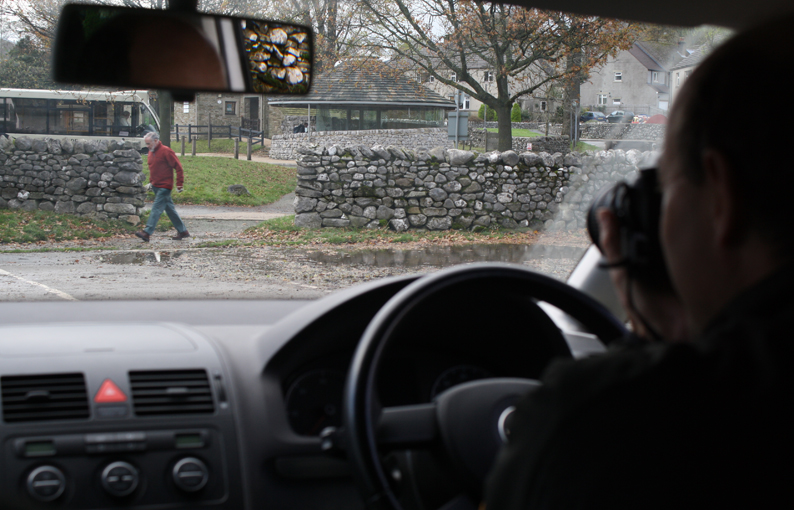 Image: Photo of private investigator (PI) in the car watching a person from a distance.